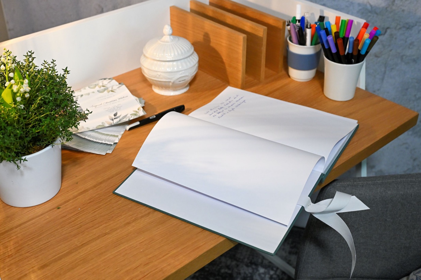 Offenes Gästebuch mit Stiften und Blumen